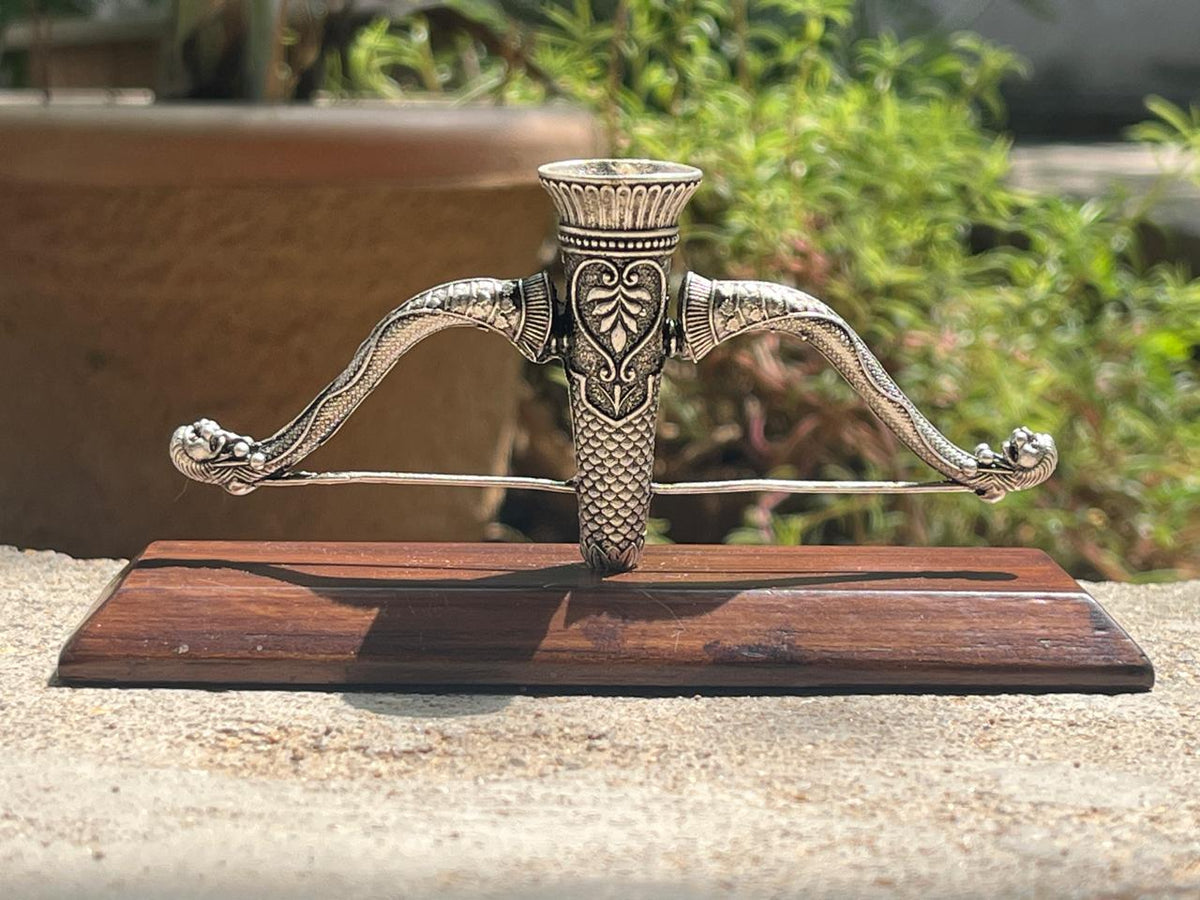 Ram Dhanush agarbatti stand in pure silver plating on a wooden stand, in daylight