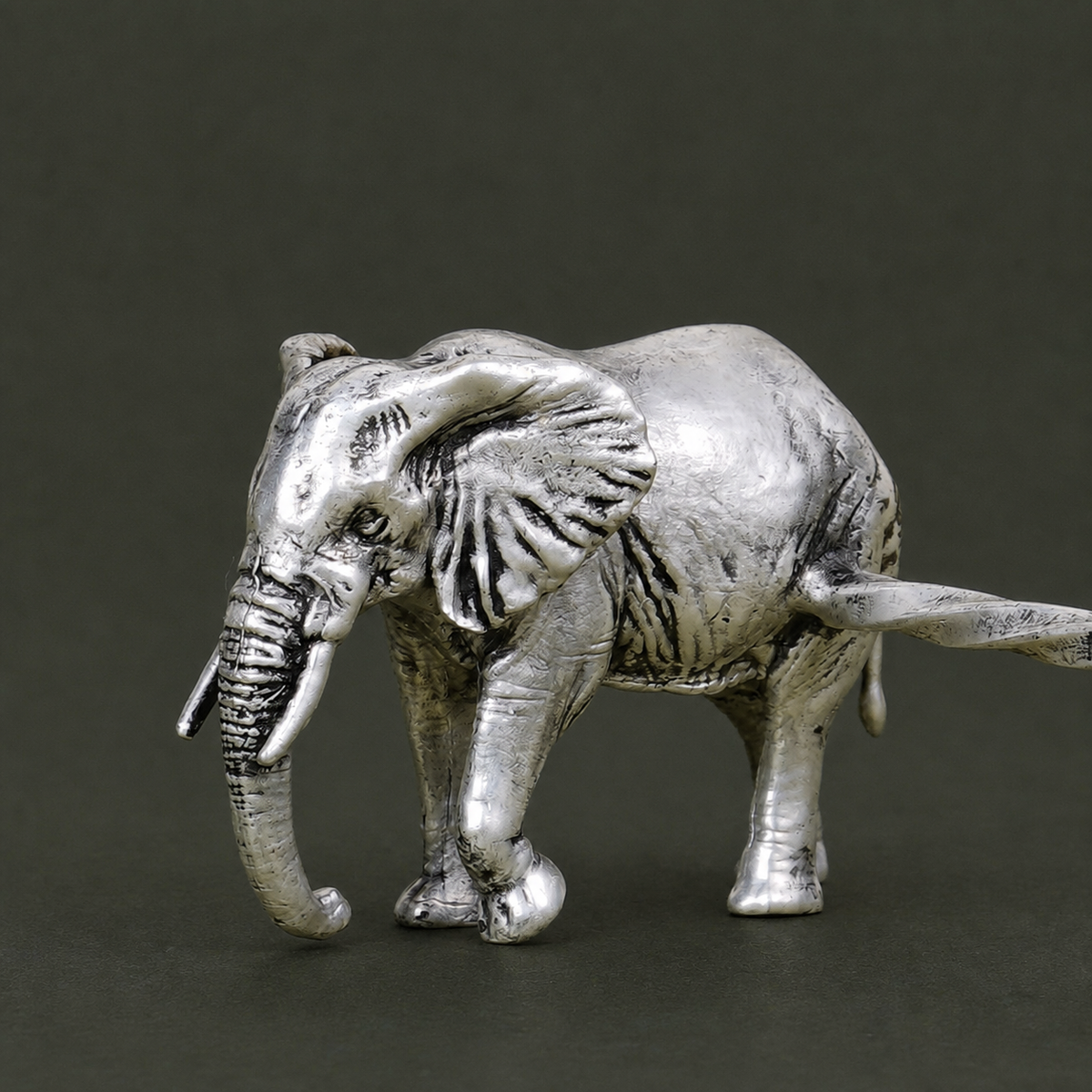Close view of the engraved silver-plated elephant and connecting spoon rest