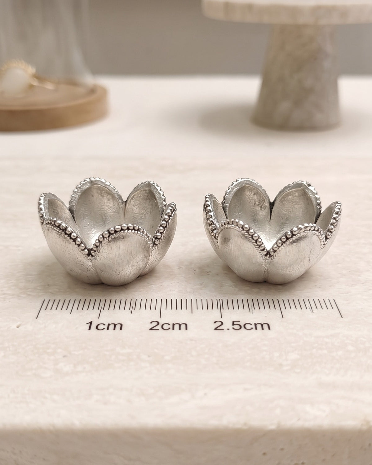 Two Kamal Katori lotus bowls in pure silver plating beside a ruler showing 2.5 cm width, one piece from the gift box