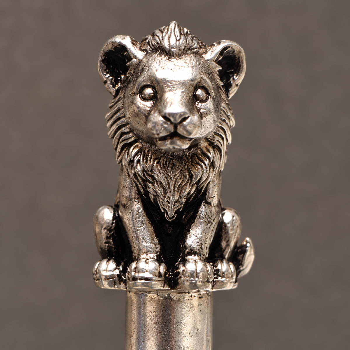 Close view of the lion cub's face, mane and paws in pure silver plating on a high-grade brass base