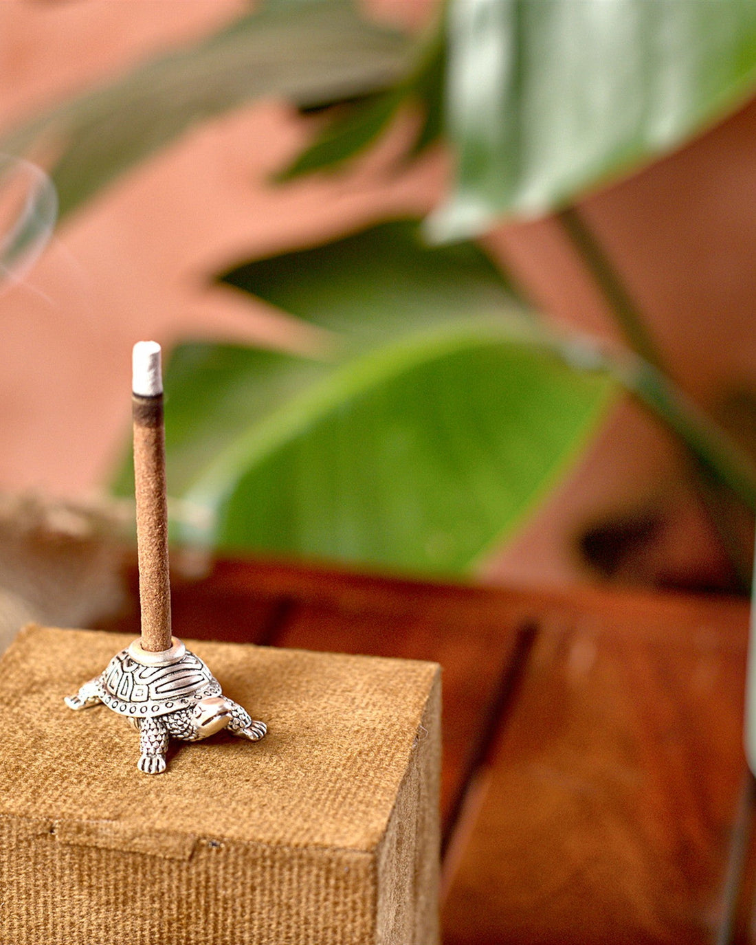 Silver-plated turtle dhoop stand holding an incense stick on its gift box
