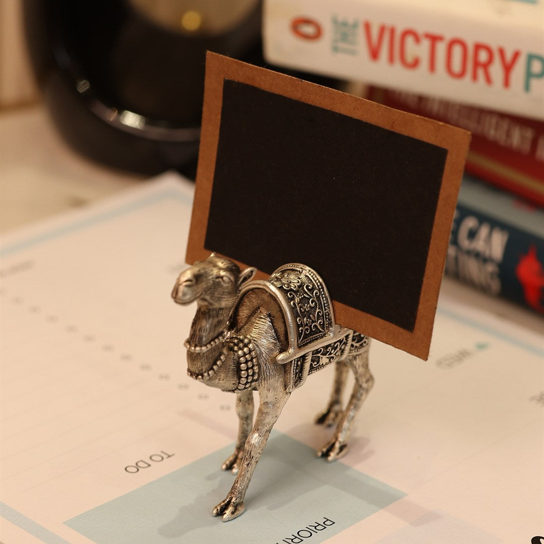 Silver camel place-card holder set for a table.